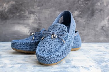 Mavi yumuşak kumaş kadın ayakkabıları. Gri bir arka planı var..