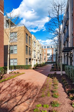 Kırmızı tuğlalı kaldırım kırmızı ve sarı tuğlalı binalar boyunca.