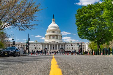 Washington 'daki Amerikan Kongre Binası yolu sarı şeritli. Beyaz bulutlu mavi gökyüzü.