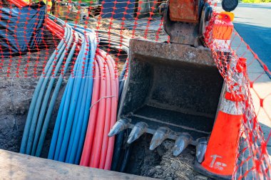 Geniş bant internet kablolarını yeraltına yerleştirmek için kazıcı ve ekipman.