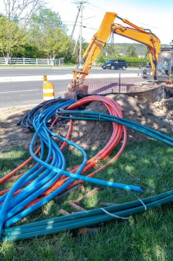 Geniş bant internet kablolarını yeraltına yerleştirmek için kazıcı ve ekipman.