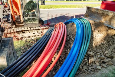 Geniş bant kablo döşemek için plastik kablolar, kazıcı ve ekipman.