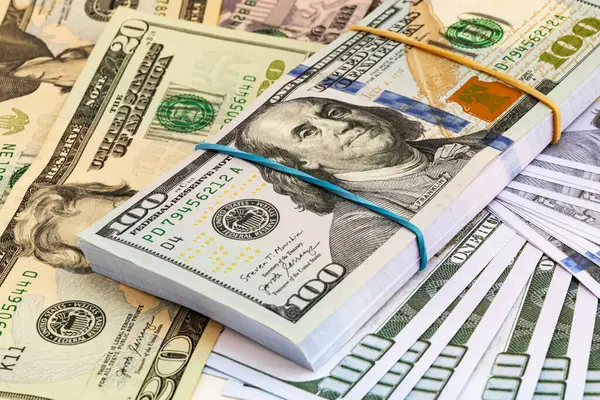 Dağıtılmış Amerikan banknotları zengin, dokulu bir fon oluşturuyor. Zenginliği, ekonomiyi ve finansal bolluğu resmetmek için ideal.