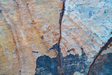 Topraksı kahverengi ve turuncu tonlarda doğal taş dokusu. Kabataslak mineral yüzeyi arka plan ya da tasarım elementleri için idealdir.