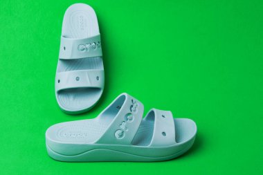 Timsah timsahları yeşil arka planda. mavi renkli timsah terliği.