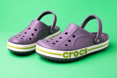 Yeşil arka planda bir çift Crocs sandaleti. Hafif plaj ayakkabıları.