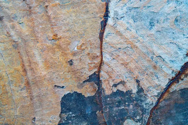 Topraksı kahverengi ve turuncu tonlarda doğal taş dokusu. Kabataslak mineral yüzeyi arka plan ya da tasarım elementleri için idealdir.