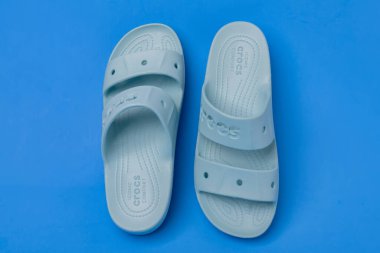 Mavi arka planda logosu olan mavi kadın terlikleri..