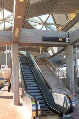 Yükseltilmiş bir metro istasyonunda yürüyen merdiven yakın plan.