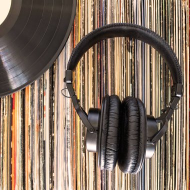 Kulaklıklar vinil plak koleksiyonunun üzerinde duruyor. Üst görünüm.