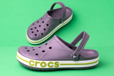 Yeşil arka planda timsah grisi plaj sandaletleri. Hafif günlük ayakkabılar..