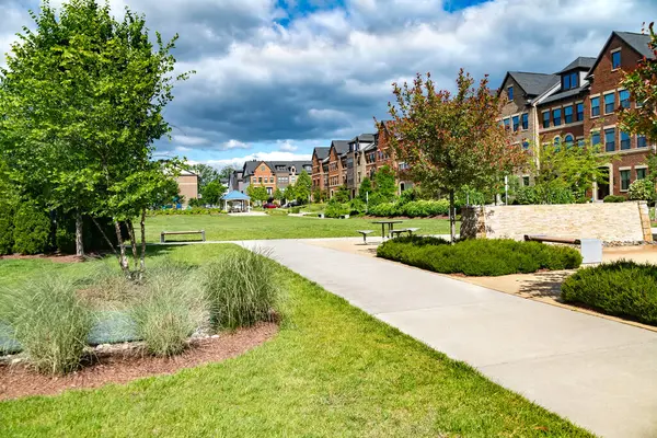 Modern tuğla evler boyunca yürüme alanı olan modern bir toplulukta büyük bir çim..