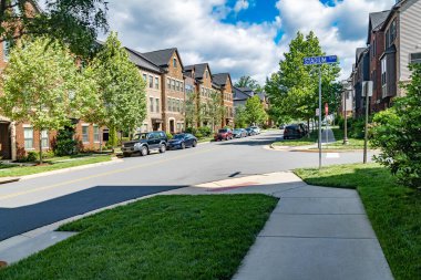 Banliyödeki yerleşim yerlerinde bir sokak. Yol boyunca çimleri olan apartman daireleri..