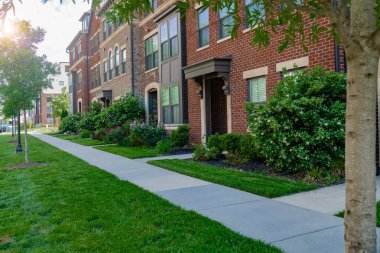 Peyzajlı, modern tuğlalı evler boyunca kaldırımlar..