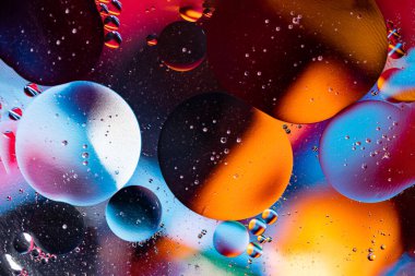 Petrol baloncuklarının hareketi. Renkli kabarcıklardan oluşan fantastik bir yapı. Soyut renkli arkaplan. Suda yakın çekim kabarcıkları.