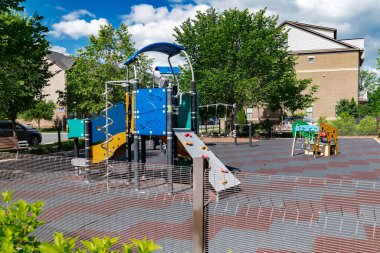 Halk avlusunda güvenli bir yüzeye sahip oyun parkı ve oyun ekipmanları.