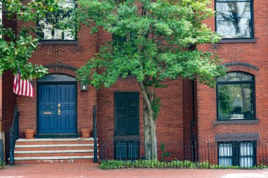 Washington, DC 'de tuğlalı bir evde mavi kapısı ve bayrağı olan bir kapı.