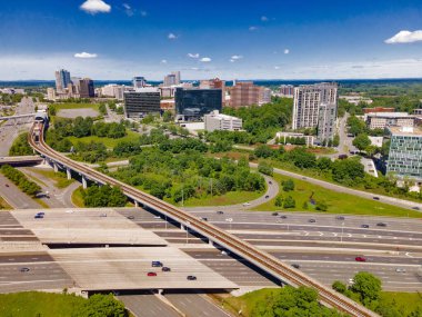Altyapısı olan modern şehir manzarası. Yükseltilmiş yollar, metro hattı ve ofis binaları kentsel gelişimi gösteriyor.