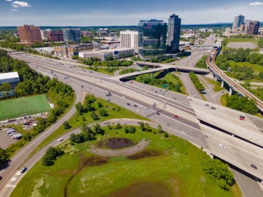 Şehir planlaması havadan bakıldığında eylemde. Kavşaklar, trafik akışları ve modern binalar manzarayı şekillendirir.