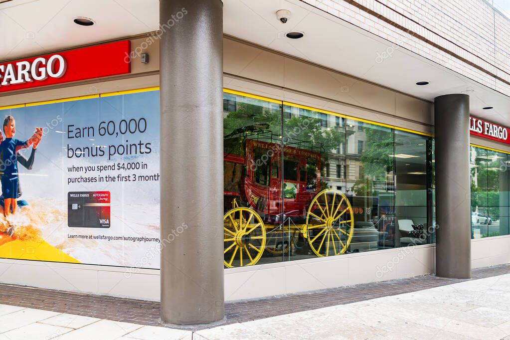 Glass storefront with advertisements and an antique carriage house at the Wells Fargo Bank in downtown Washington DC.