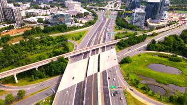 Gökdelenleri ve peyzajı olan modern bir şehirde ekspres yol ve yükseltilmiş bir otoyol manzarası.