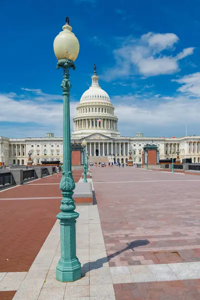 Güneşli bir günde ABD kongre binasının önünde yürüyen turistler.