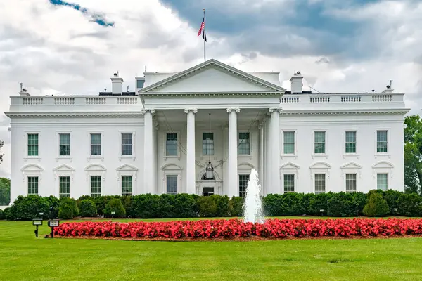 Beyaz Saray 'a yakın çekim. Kırmızı çiçekli ve çeşmeli biçilmiş çimenler.