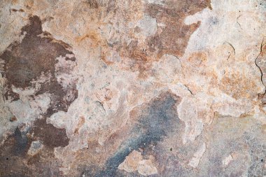 Yıpranmış taş plaka üzerindeki pas ve aşınma. Toprak tonlu doğal taş dokusu..