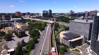 Gökdelenler, çatılardaki güneş panelleri, otoyol ve metro istasyonları. Kamera metro hattı boyunca hareket ediyor..