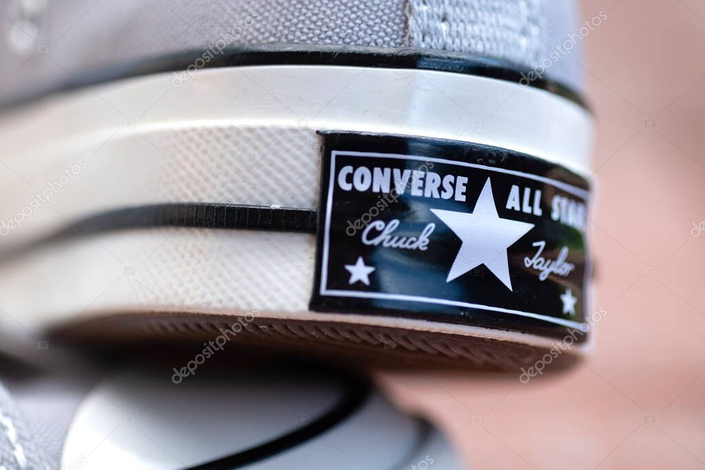 Everyday Sneakers Converse. Logo in Focus. Grey canvas shoes captured in natural light