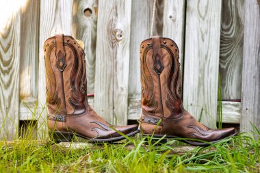 Rodeo Moda Simgesi. Geleneksel kovboy çizmeleri kırsal Amerika 'da çitin yakınındaki çimlerde.