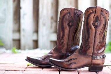 Bir çift el yapımı kovboy çizmesi. Kırsal bir ortamda deri batı ayakkabıları..
