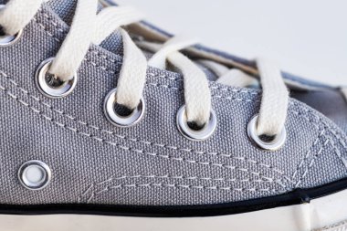 Vintage spor ayakkabılarını bağla. Minimalist gri spor ayakkabıları beyaz arka planda.