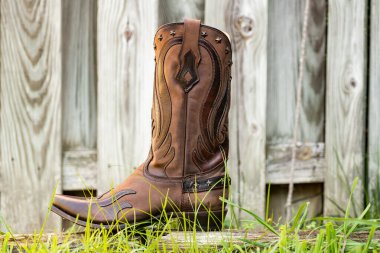 Geleneksel kovboy çizmeleri kırsal alanda dimdik ayakta duruyor. Kırsal moda ve sınır ruhu.