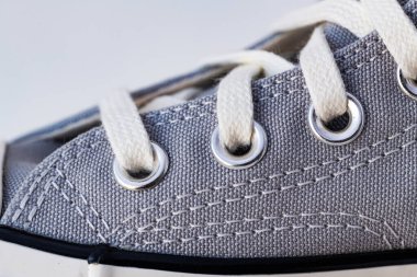 Vintage spor ayakkabılarını bağla. Minimalist gri spor ayakkabıları beyaz arka planda.