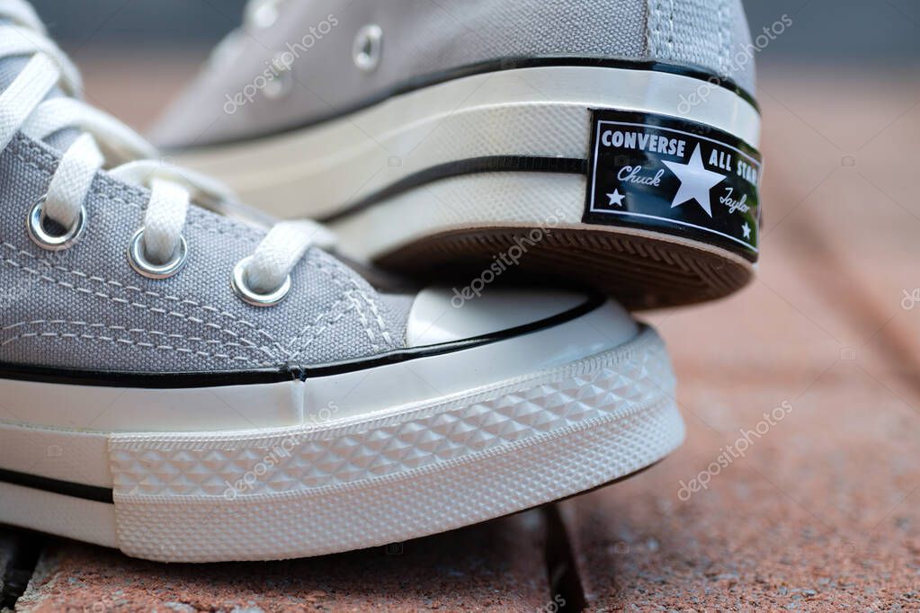 Everyday Sneakers Converse. Logo in Focus. Grey canvas shoes captured in natural light