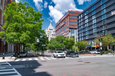 Washington DC 'de yoğun kavşak. Modern gökdelenler ve tarihi yapılar arasında arabalar ve yayalar