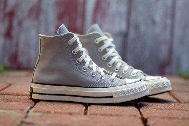 Klasik Converse Sneakers on Brick. Kentsel yaşam tarzı, zamansız sokak giysisinin temeli ile buluşuyor.