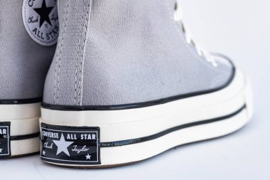 Beyaz arka planda Chuck Taylor All Star Lisesi 'nin gri spor ayakkabıları. Logo görünümü.
