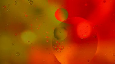 Mavi-kırmızı-sarı arka planda yüzen yağ damlaları. Bilimsel araştırmalar soyut.