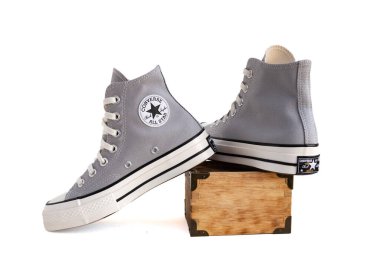 Moda Gri Converse Chuck Taylor Spor Ayakkabıları. Tahta bir sandıkta. Beyaz bir arkaplanda izole edilmiş.