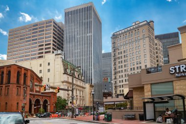 Yüksek binalı Baltimore caddesi manzarası. Modern kuleler, kırmızı tuğla cepheler ve şehir merkezindeki şehir geometrisi..