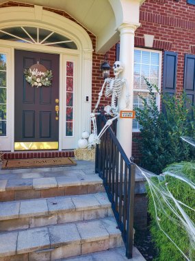 İskelet ve örümcek ağı evin eşiğinde. Cadılar Bayramı için dekore edilmiş evin dekorasyonu.