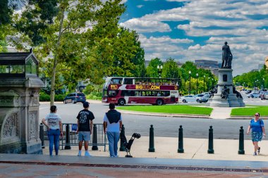 Başkentteki Büyük Otobüs Anıtı. Washington, D.C. 'de ikonik simgelerin ve yeşil alanların yanından geçen üstü açık bir tur otobüsü..