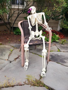 Oturan İskelet 'le Şenlikli Kapı. Tarihi şehir caddesinde Cadılar Bayramı ruhu canlı.