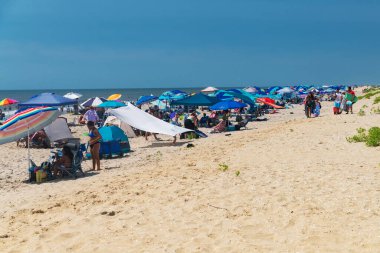 Plaj kalabalığı ve okyanus manzaralı popüler tatil beldesi