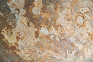 Düz desenli granit bir levhanın yakın çekimi, kirli aşınma izleri ve kırsal bir his. 