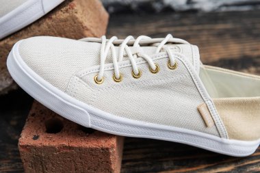 Tommy Hilfiger 'a yakın çekim, düşük bej ayakkabılar, kalın beyaz lastik tabanlı, klasik ahşap yüzey..