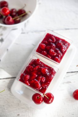 Hafif ahşap arka planda kiraz soslu kremalı panna cotta. Pişirmeden İtalyan Tatlıları. Sevgililer Günü