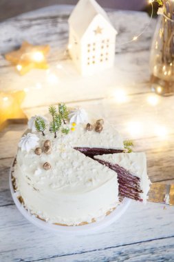 Altın fındıklı, fındıklı, yeşil yılbaşı ağaçlı, hindistan cevizli ve hafif arkaplanlı kremalı kış pastası. Ahududu kremalı çikolatalı pasta kesiyorum.